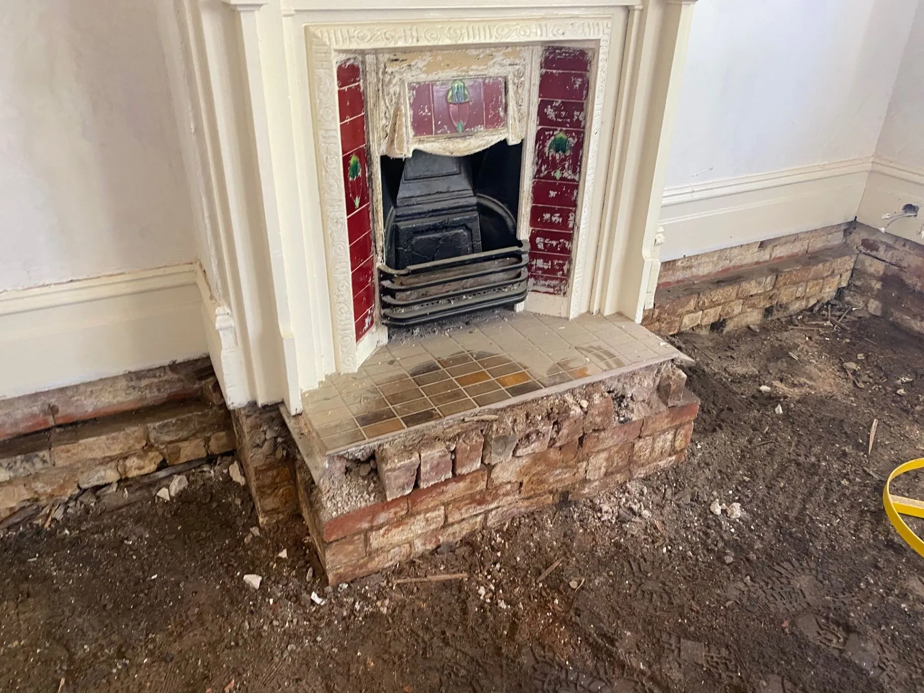 Decorative red tiled fireplace and brick hearth exposed during Elsternwick repair work